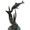 dolphins dancing around sea weed sculpture